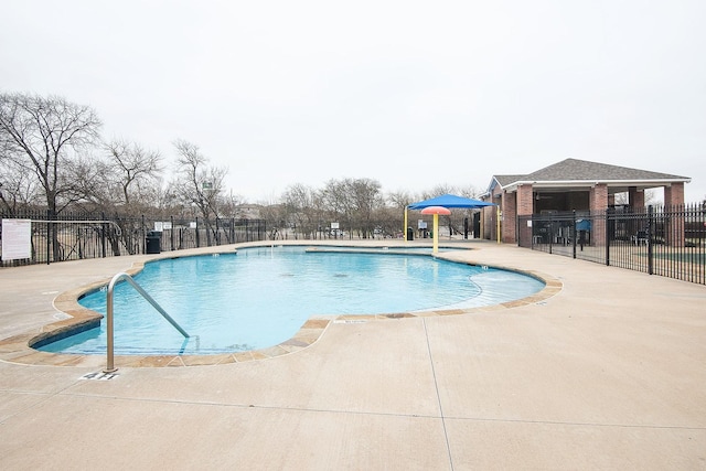 pool with a patio and fence