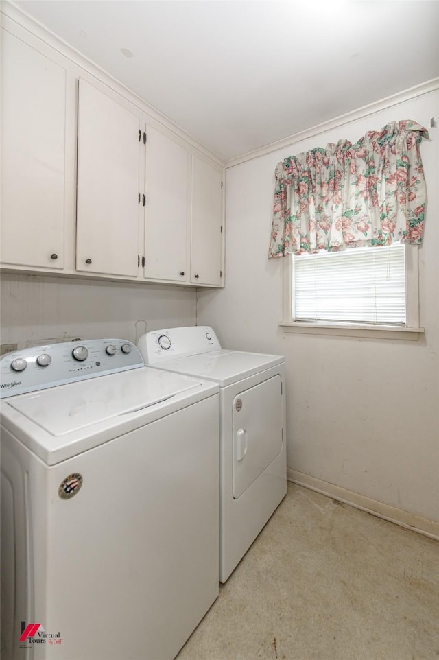 washroom featuring independent washer and dryer, cabinet space, and baseboards