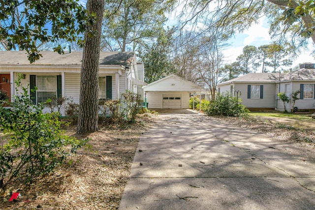 view of front facade with concrete driveway, a detached garage, and an outdoor structure