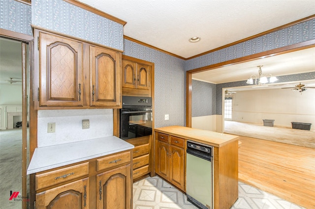 kitchen with ceiling fan with notable chandelier, black oven, ornamental molding, light countertops, and wallpapered walls