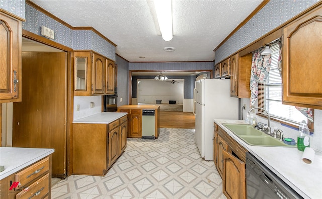 kitchen with light floors, brown cabinetry, a sink, black appliances, and wallpapered walls