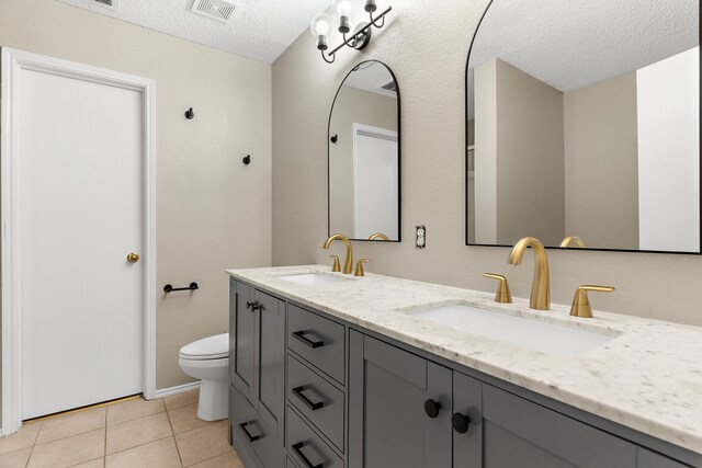 full bathroom featuring a textured ceiling, visible vents, a sink, and tile patterned floors