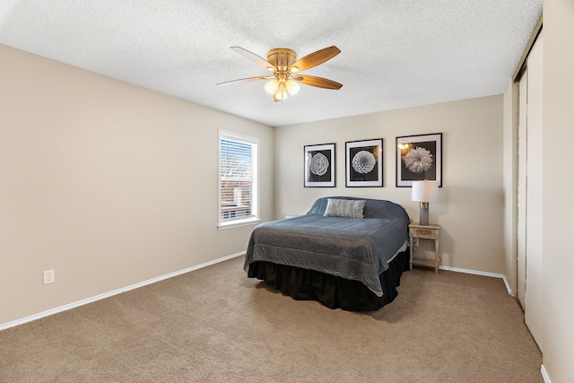 bedroom featuring a closet, carpet flooring, a textured ceiling, and baseboards