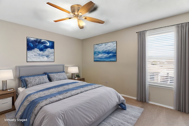 bedroom with light carpet, ceiling fan, and baseboards