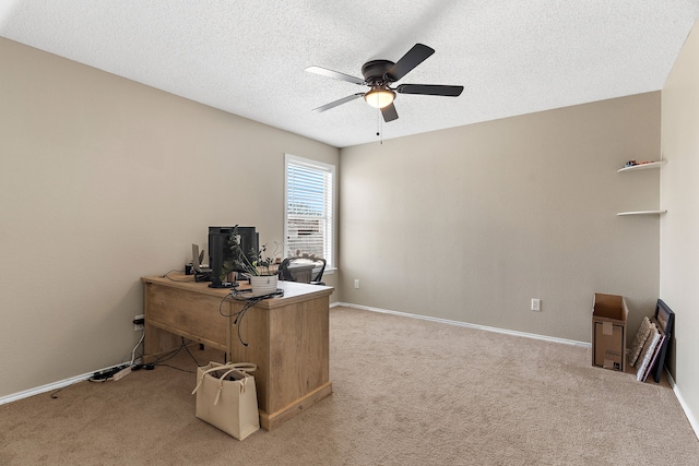 office with a textured ceiling, baseboards, a ceiling fan, and light colored carpet