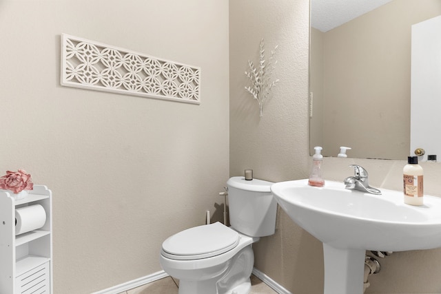 bathroom with baseboards and toilet