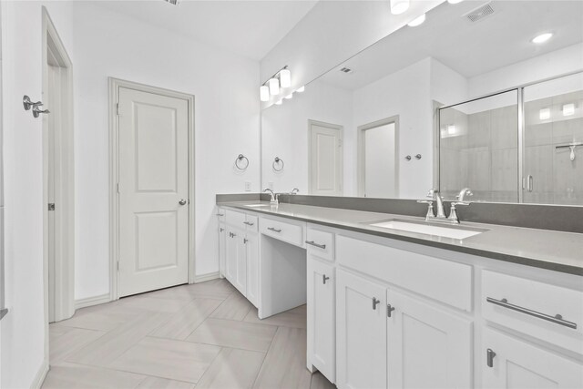 bathroom featuring visible vents, a sink, a shower stall, and double vanity