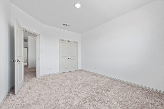 unfurnished bedroom featuring a closet, carpet flooring, visible vents, and baseboards