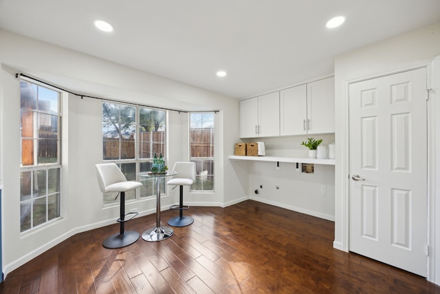 living area featuring baseboards, wood finished floors, and recessed lighting