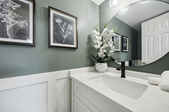 bathroom featuring a textured wall and vanity