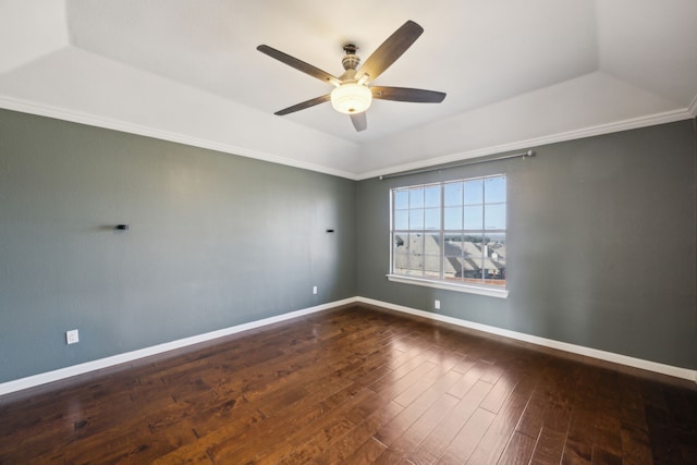 spare room with a tray ceiling, wood-type flooring, baseboards, and a ceiling fan