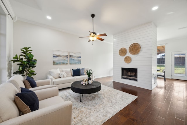 living area with baseboards, dark wood finished floors, ceiling fan, a fireplace, and recessed lighting