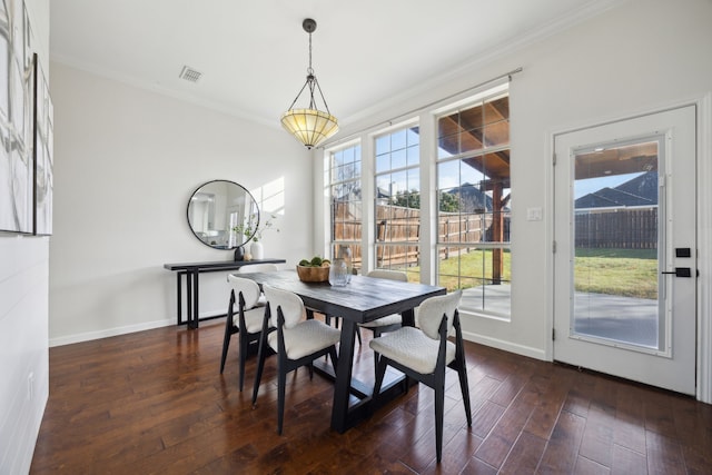 dining space featuring dark wood-type flooring, plenty of natural light, and ornamental molding