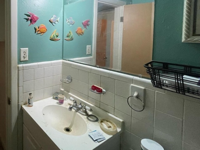 half bathroom featuring tile walls and vanity