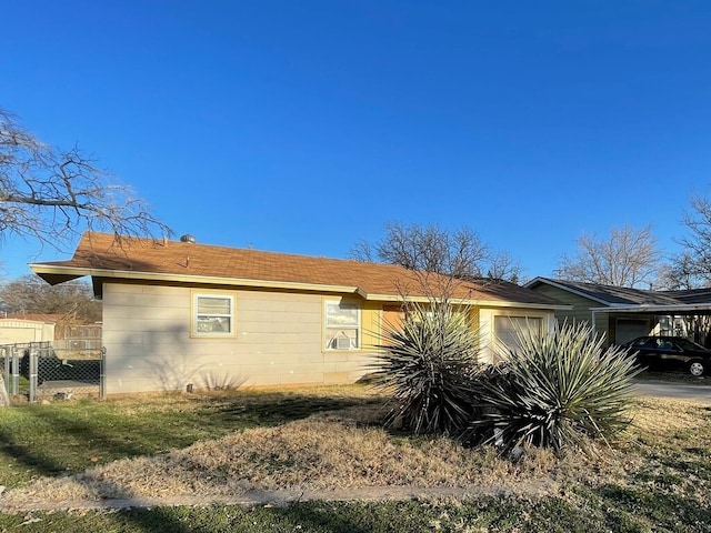 view of side of home with a carport and fence