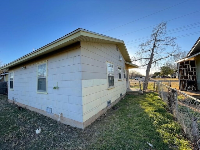 view of property exterior with a yard, crawl space, and fence