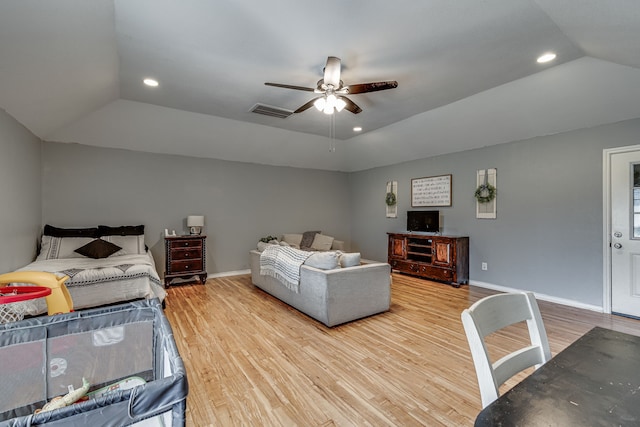 bedroom featuring lofted ceiling, wood finished floors, visible vents, and baseboards