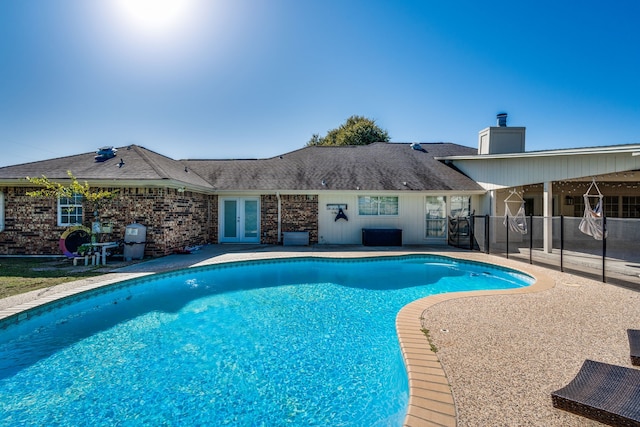 view of pool with a fenced in pool, fence, a patio, and french doors