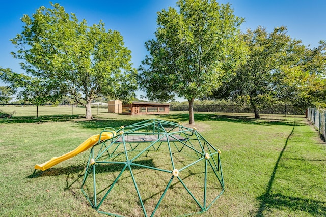 view of community featuring a yard, a playground, and fence