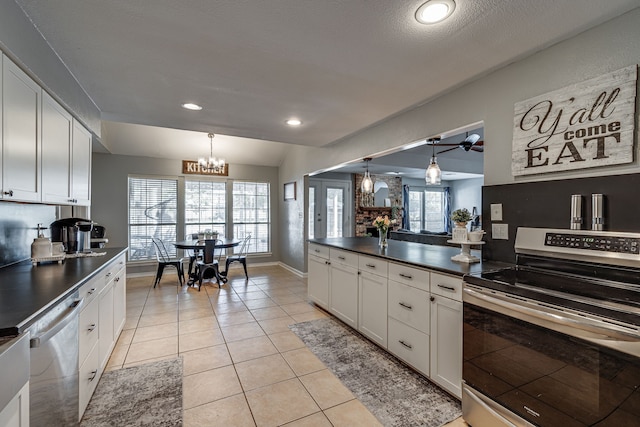 kitchen with light tile patterned floors, stainless steel appliances, dark countertops, and white cabinets