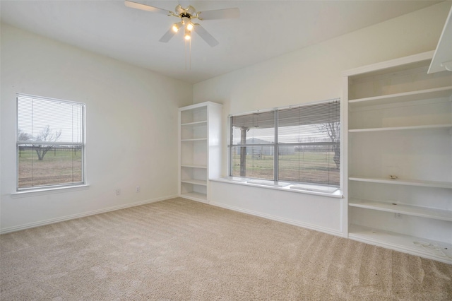 empty room featuring ceiling fan, plenty of natural light, carpet flooring, and baseboards