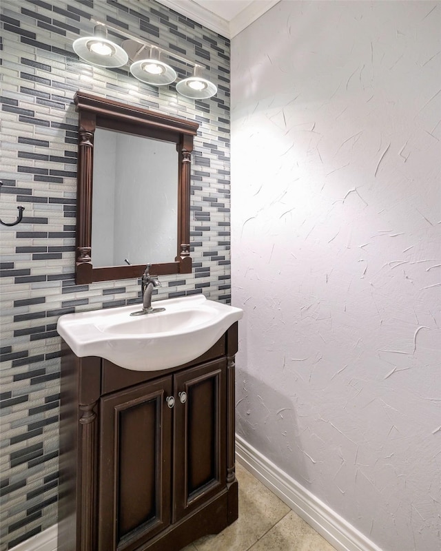 bathroom with ornamental molding, tile patterned flooring, vanity, and baseboards