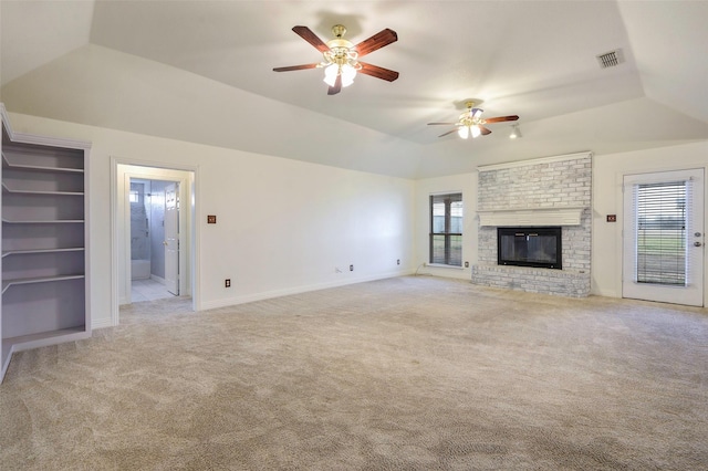 unfurnished living room featuring light carpet, a fireplace, visible vents, baseboards, and a tray ceiling