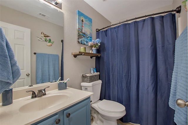 bathroom featuring toilet, a shower with curtain, visible vents, and vanity