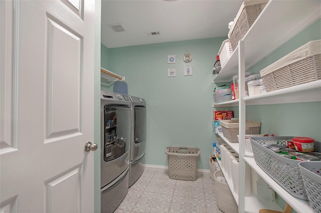 clothes washing area featuring light tile patterned floors, laundry area, visible vents, baseboards, and washing machine and clothes dryer