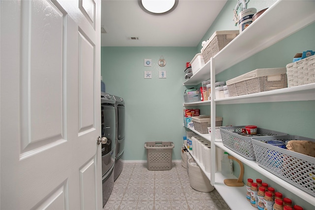 storage area featuring visible vents and washer and clothes dryer