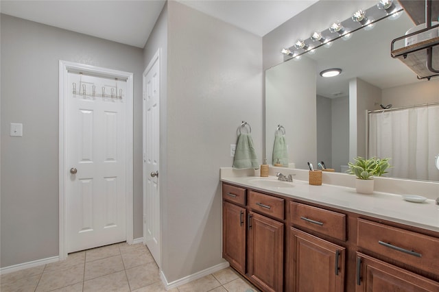 bathroom featuring vanity, baseboards, and tile patterned floors