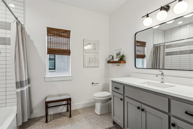 full bathroom featuring baseboards, toilet, speckled floor, shower / bath combination with curtain, and vanity