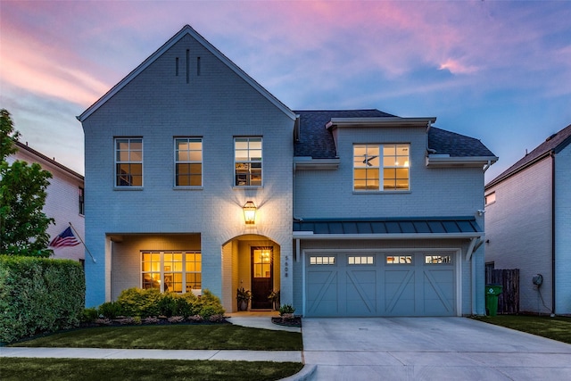 view of front of home featuring metal roof, driveway, brick siding, and a standing seam roof