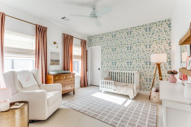 bedroom featuring wallpapered walls, visible vents, and a ceiling fan