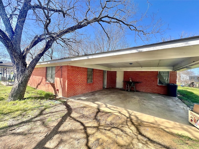 exterior space with an attached carport, brick siding, and driveway