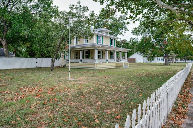 view of front of home with a front yard, covered porch, and fence private yard