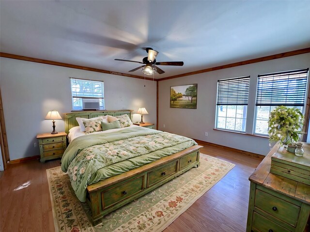 bedroom featuring a ceiling fan, baseboards, crown molding, and wood finished floors