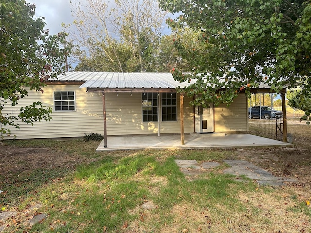 rear view of house featuring metal roof and a patio area