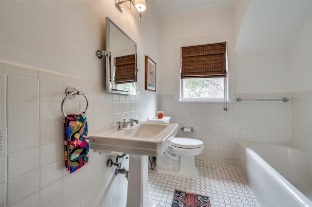 6306 Tremont St, Dallas, TX 75214 - full bathroom featuring tile walls, a bathtub, toilet, tile patterned flooring, and wainscoting