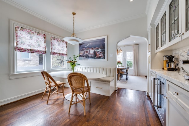 6306 Tremont St, Dallas, TX 75214 - dining room with arched walkways, dark wood-style flooring, crown molding, baseboards, and beverage cooler