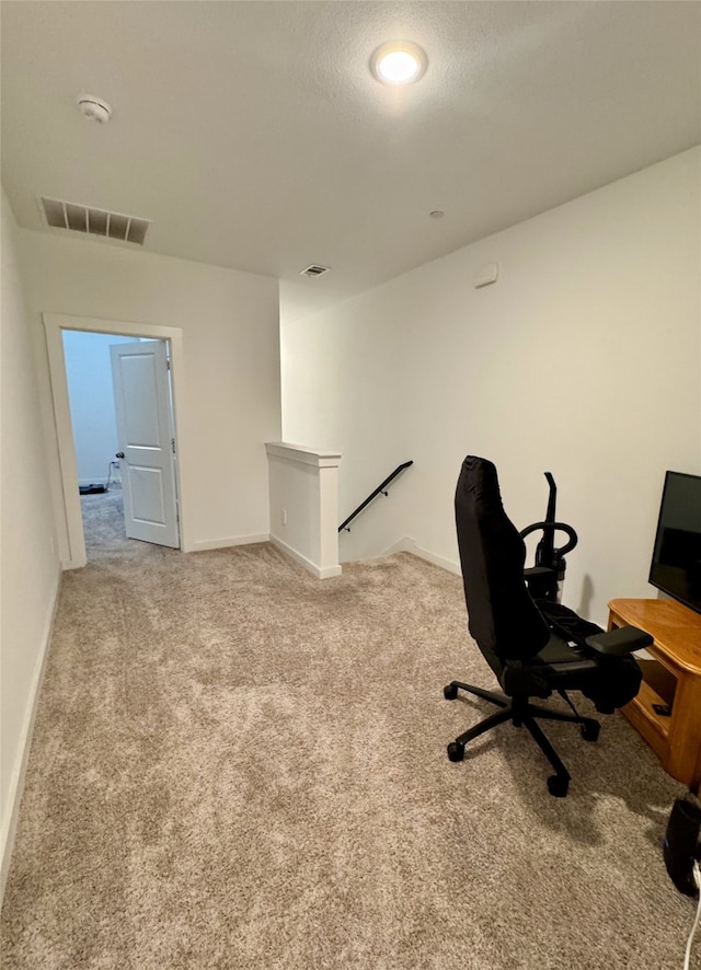 office space featuring a textured ceiling, carpet, visible vents, and baseboards