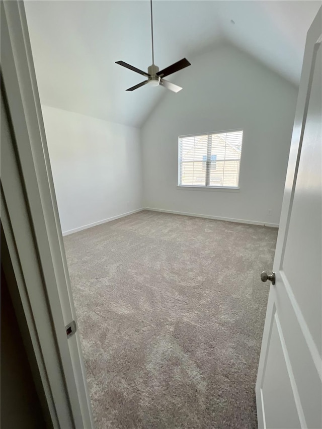 unfurnished room with lofted ceiling, carpet floors, ceiling fan, and baseboards