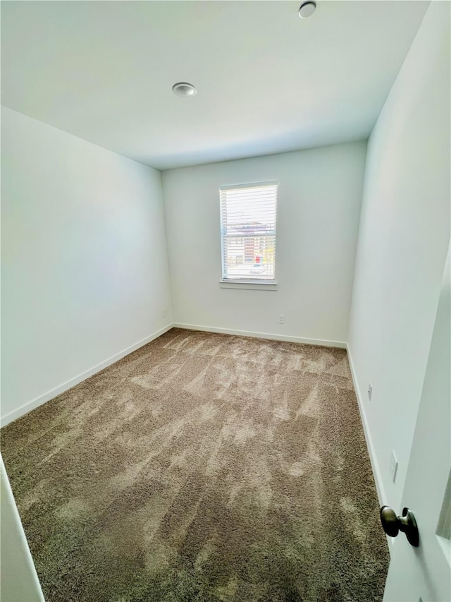 carpeted spare room with baseboards