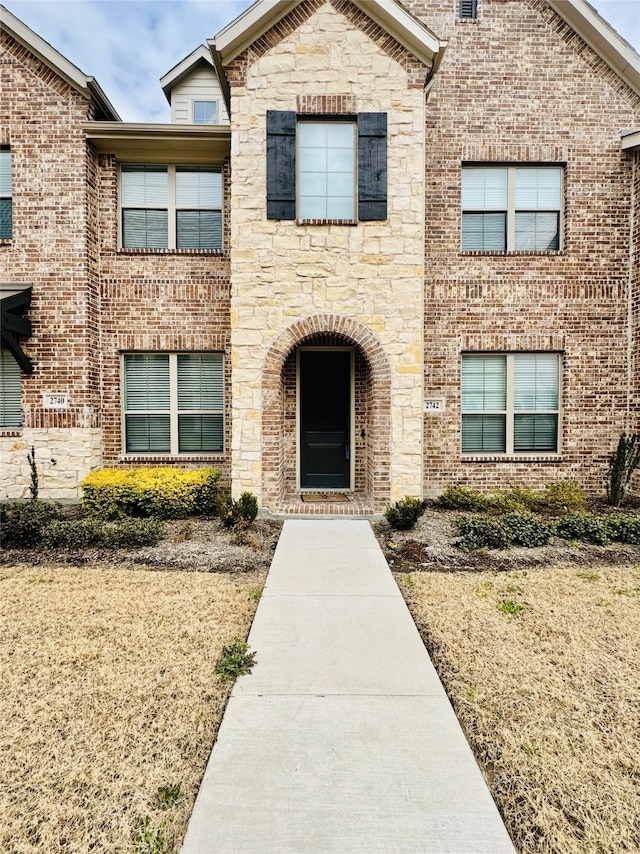 view of front of property featuring stone siding and brick siding