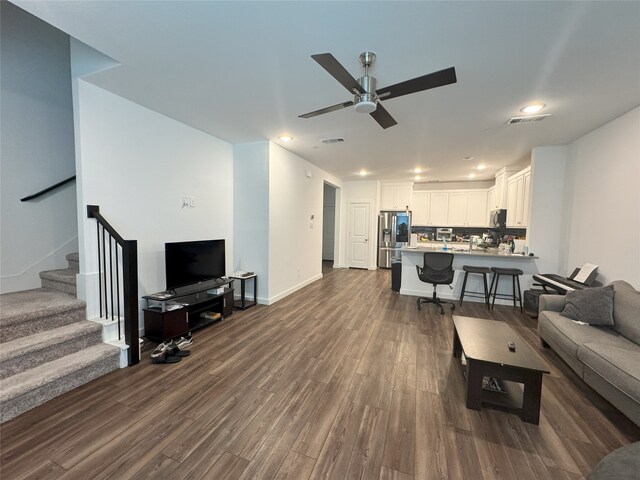 living room featuring stairs, a ceiling fan, wood finished floors, and recessed lighting