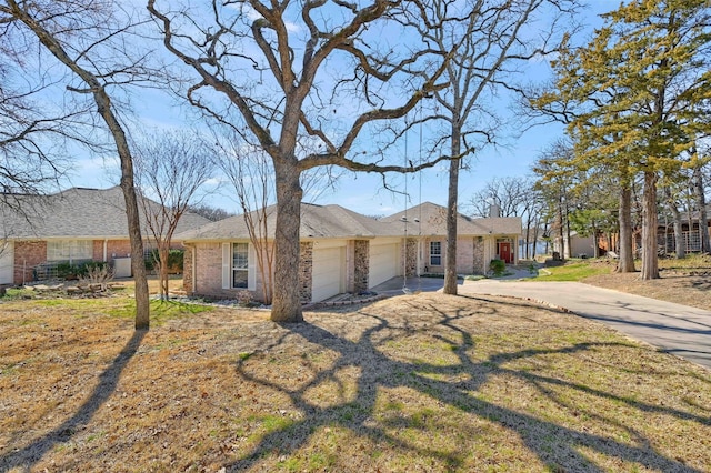 single story home featuring an attached garage, brick siding, concrete driveway, a chimney, and a front yard