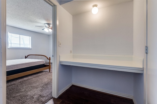 bedroom featuring dark wood-style floors, baseboards, and a textured ceiling