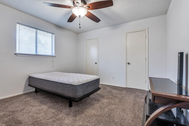 carpeted bedroom with baseboards, a ceiling fan, and a textured ceiling