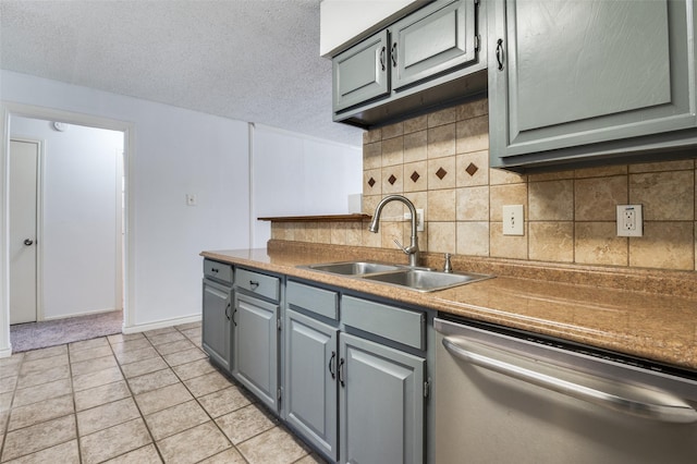 kitchen featuring a sink, stainless steel dishwasher, gray cabinets, and decorative backsplash