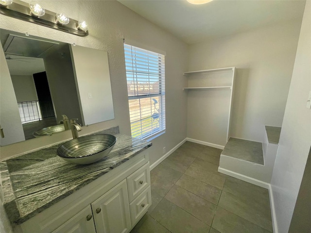 bathroom with vanity, baseboards, and tile patterned floors